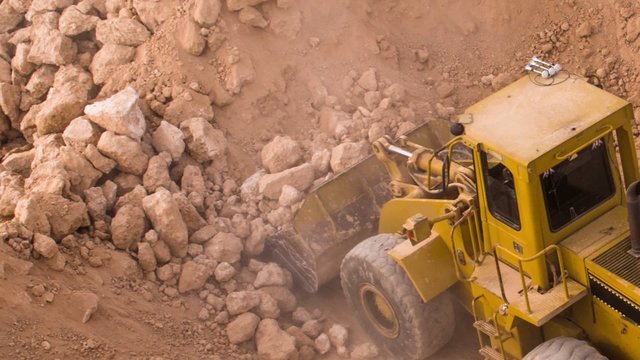 top view excavator loading crushed rock on dumper truck