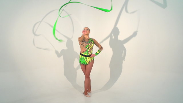 Beautiful acrobat dancing with a sash in slow motion