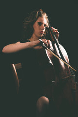 Sitting Young Woman Playing a Cello Instrument