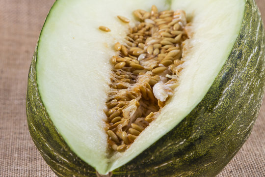 cut green melon with seeds on raffia