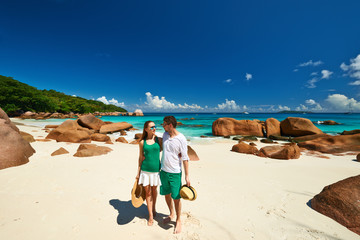 Couple in green walking on a beach at Seychelles