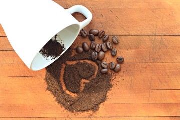 heart on coffee grounds and beans scattered sunlit background