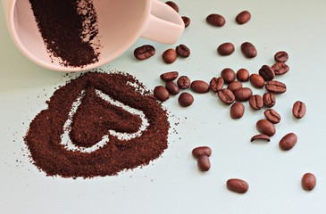 heart drawn on coffee grounds and beans scattered cup