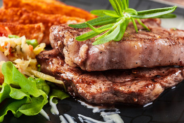 Portion of beef steak served with roast potatoes