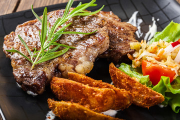 Portion of beef steak served with roast potatoes