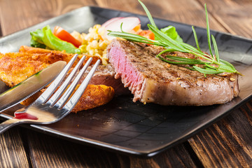 Portion of beef steak served with roast potatoes