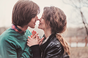 close up outdoor portrait of happy young couple kissing