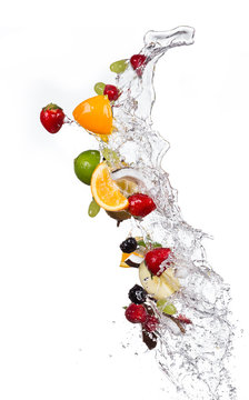 Mix of fruits with water splashes on white