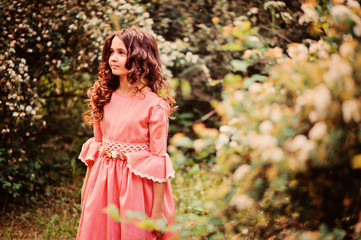 smiling child girl in pink princess dress in summer forest