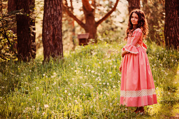 happy child girl dressed as fairytale princess in summer forest