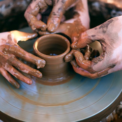 Hands working on pottery wheel