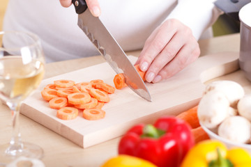 Close up of female hands cutting vegetables.