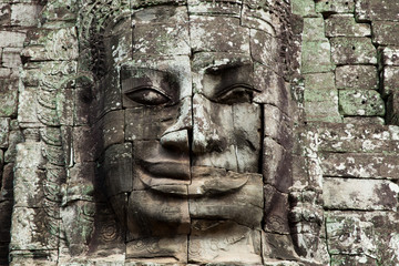 Fototapeta na wymiar The stone face of the khmer king on the wall of Bayon Temple