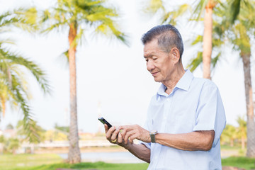 Asian senior man reading message on smartphone