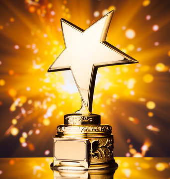 gold star trophy against shiny sparks background