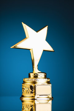gold star trophy against blue background