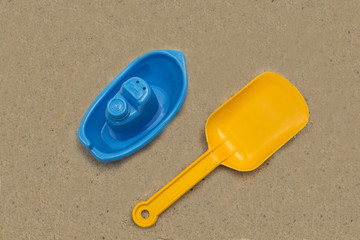 Fototapeta na wymiar Plastic toy boat and blade on sand isolated on white