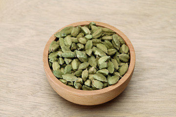 Cardamom pods in a wooden bowl