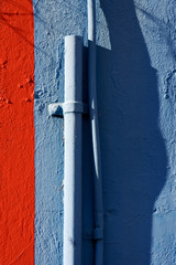 blue colored pipe and red wall