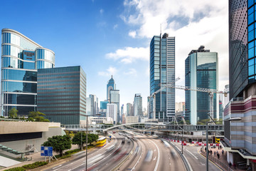 traffic and buildings at modern city hong kong during daytime.