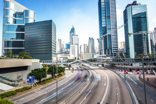 traffic and buildings at modern city hong kong during daytime.