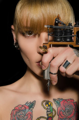 tattooed beautiful woman with tattoo machine