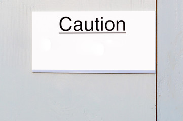 Caution sign board on wooden wall