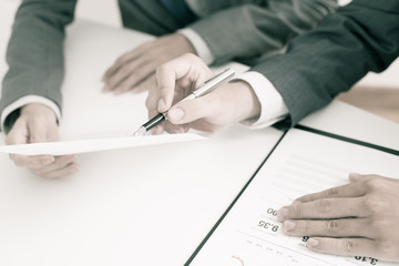 Two businessmen looking at report and having a discussion in off