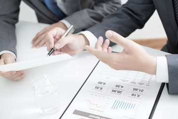 Two businessmen looking at report and having a discussion in off