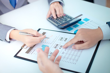 Two businessmen looking at report and having a discussion in off