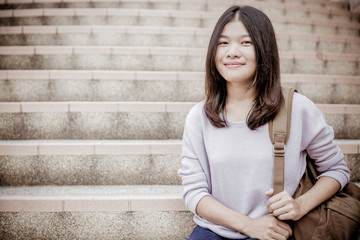 attractive female college student sitting on stairs