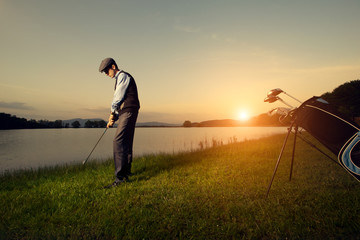 Golf. Golfer playing at sunset.