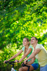 Fototapeta premium Young couple on bicycles in the park