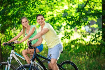 Young couple on bicycles outdoors