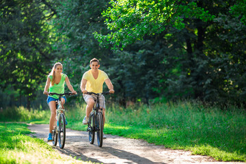 Smiling couple on bicycles in summer