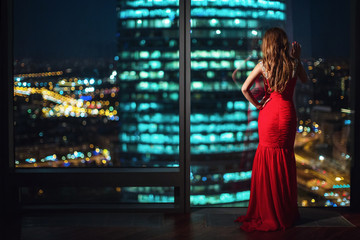 Obraz na płótnie Canvas Beautiful girl at the window at night