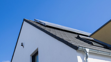 Weisse Fassade mit Solar panels und Dachrinne