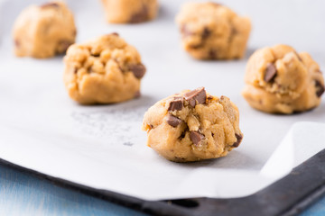 Raw cookie dough on a baking tray with parchment paper