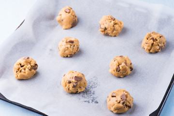 Raw cookie dough on a baking tray with parchment paper