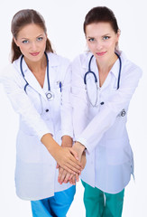 Fototapeta premium Young woman doctor stacking hands together over white background