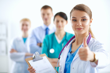 Young happy female doctor showing thumbs up