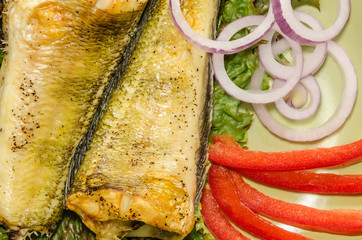 Baked shad with vegetables at dish close up