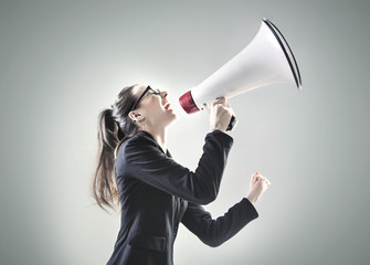 Portrait of a young businesswoman yelling over the megaphone