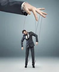Foto op Aluminium conceptual picture of a boss pulling the strings © konradbak