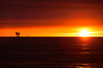 Fototapeta na wymiar Oil platform on the North Sea at sunset