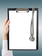 Female doctor's hand holding blank medical clipboard and stethos