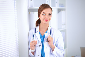 Woman doctor is standing near window