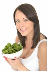 Happy Attractive Young Woman Holding a Plate of Fresh Spinach