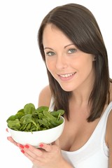 Happy Attractive Young Woman Holding a Plate of Fresh Spinach