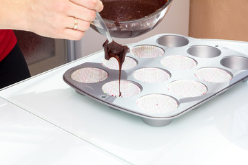 Baker pours chocolate into a mold for baking